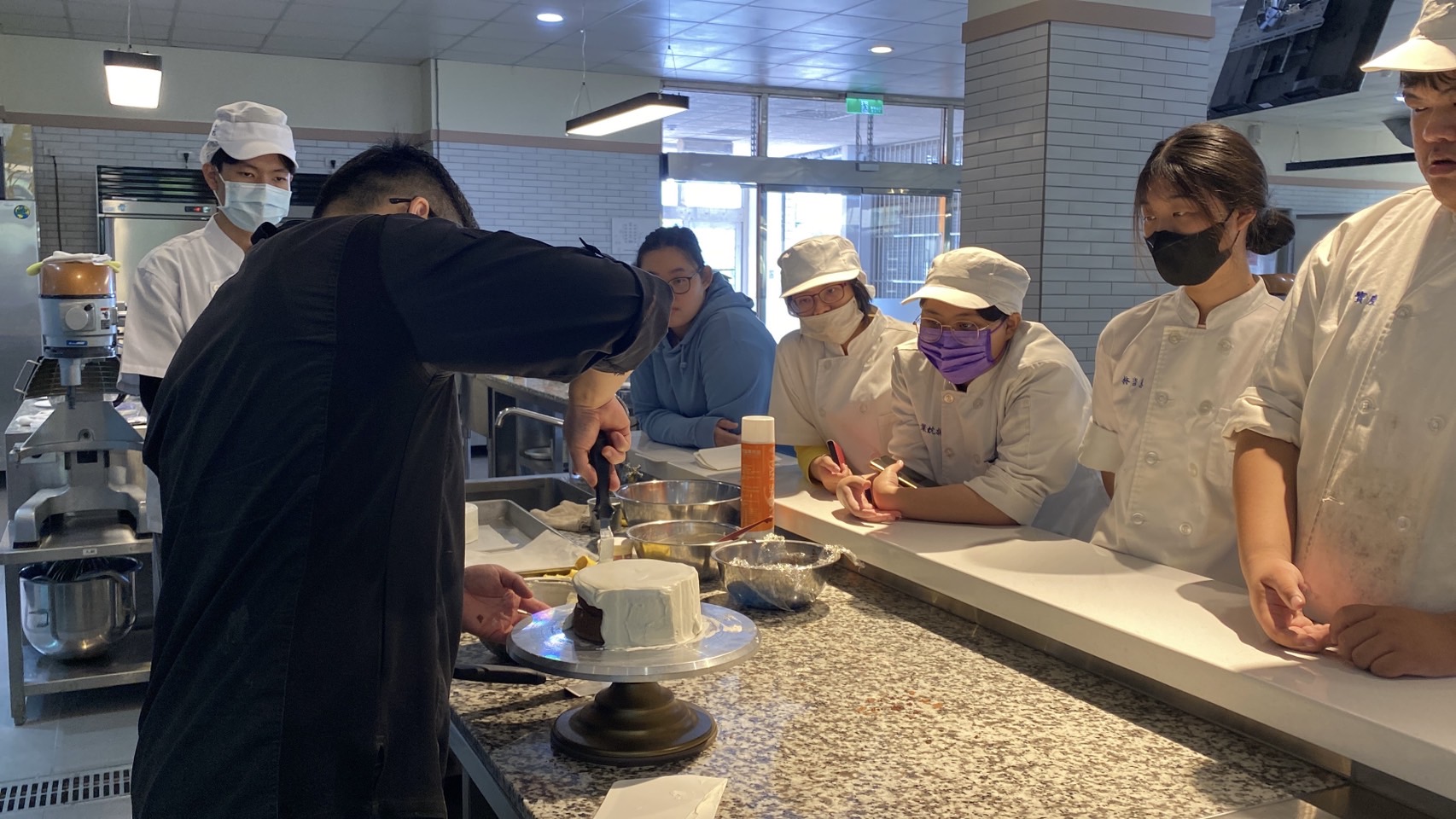 老師示範蛋糕抹面,學員努力把老師的動作記在腦海中.jpg